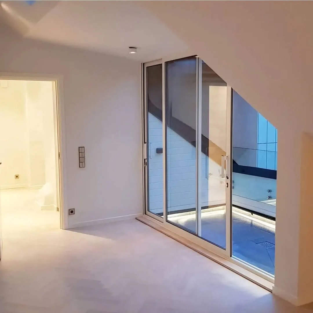 Cerramiento acristalado de terraza interior con iluminación indirecta y acabados modernos