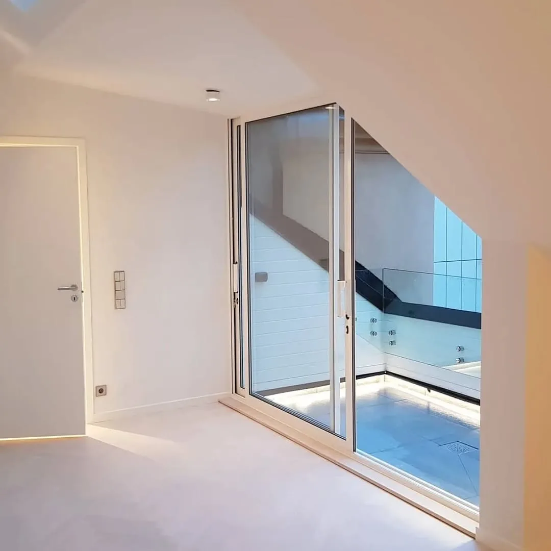 Carpintería de aluminio y grandes ventanales de salida a terraza interior en ático reformado