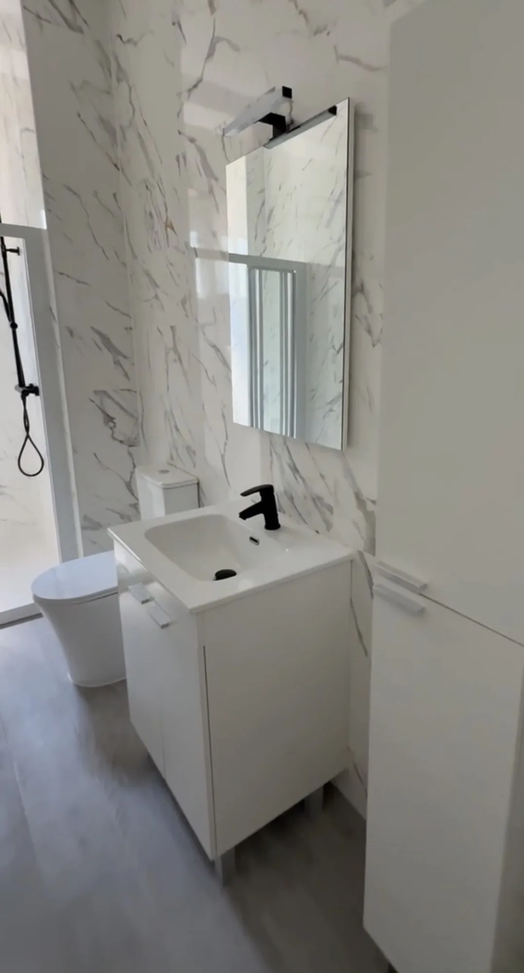 Mueble de baño blanco con lavabo integrado, espejo retroiluminado y azulejos efecto mármol — Grupo Cárdenas Rojas Valencia